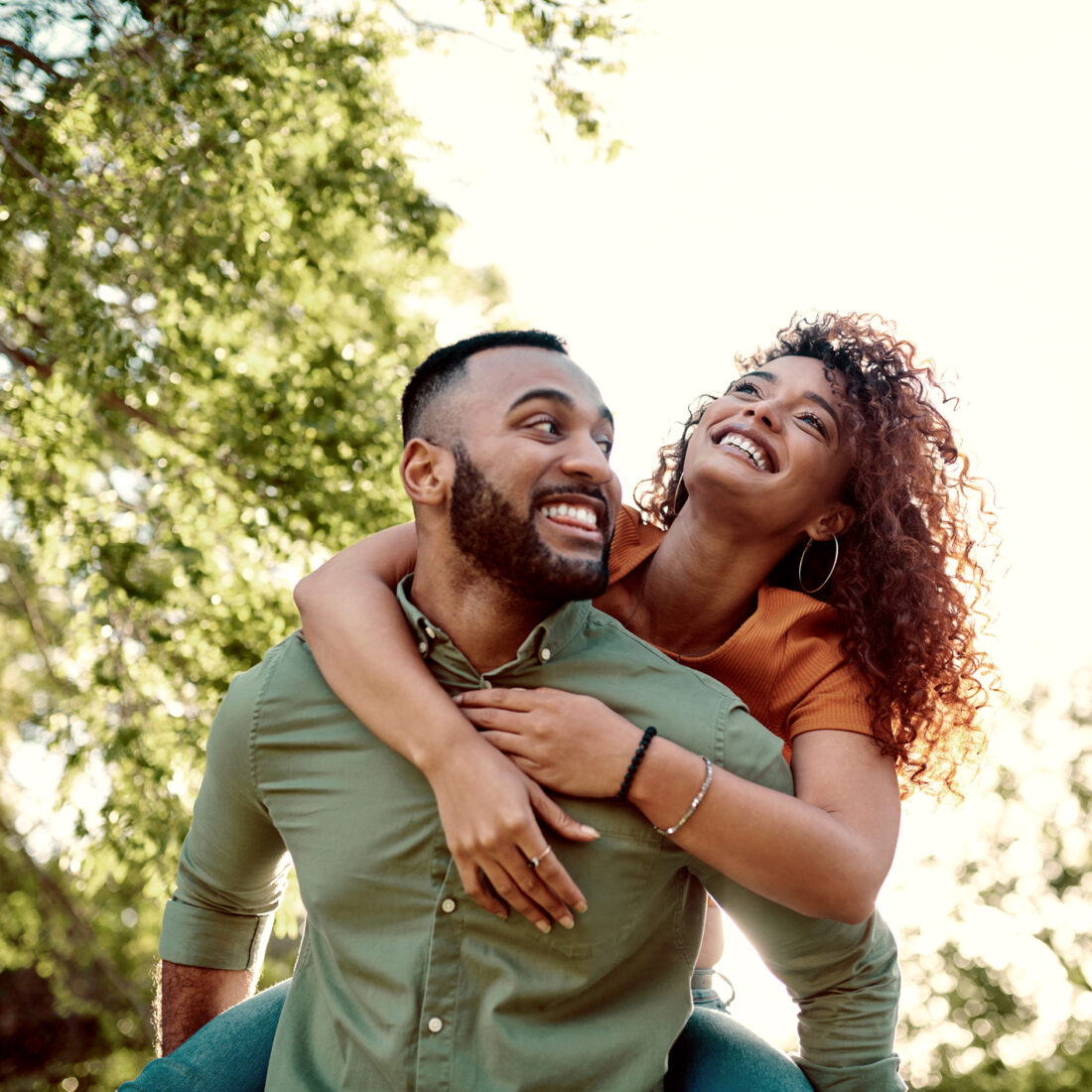 Shot of a young man giving his girlfriend a piggyback ride outdoors