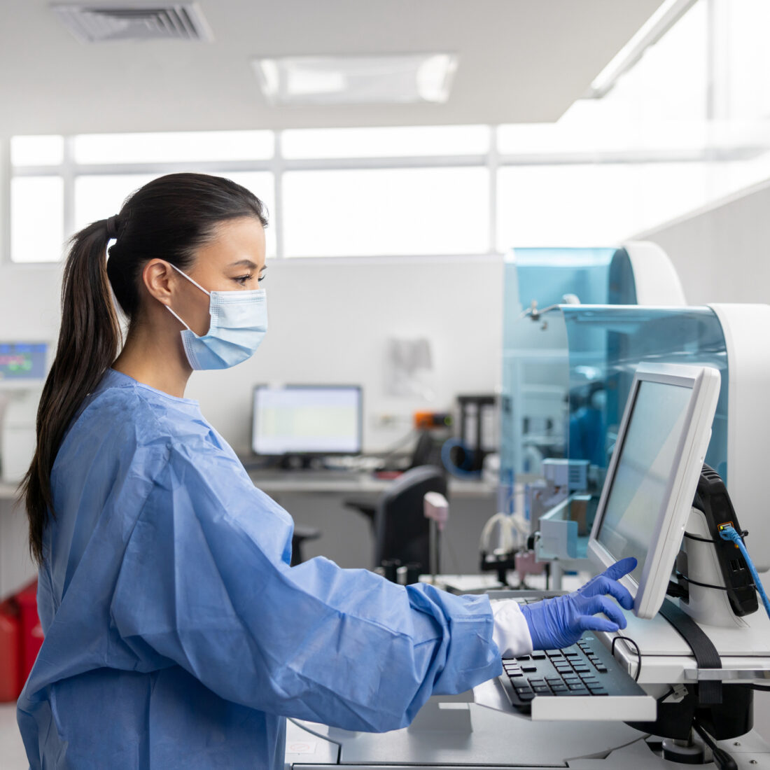 Latin American technician working at the hospital laboratory analyzing blood tests