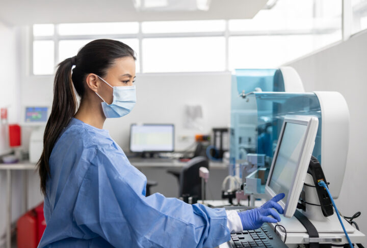 Latin American technician working at the hospital laboratory analyzing blood tests