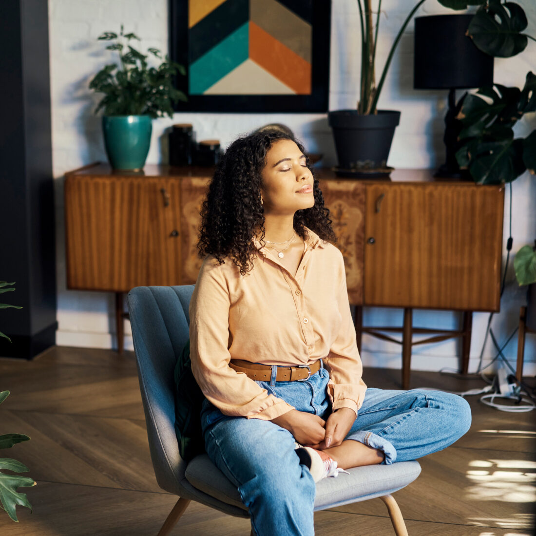 Peace, relax and happy mindset of a woman from Indonesia taking a mind and meditation home break. Happiness of woman on a house living room lounge chair thinking about life, gratitude and self care